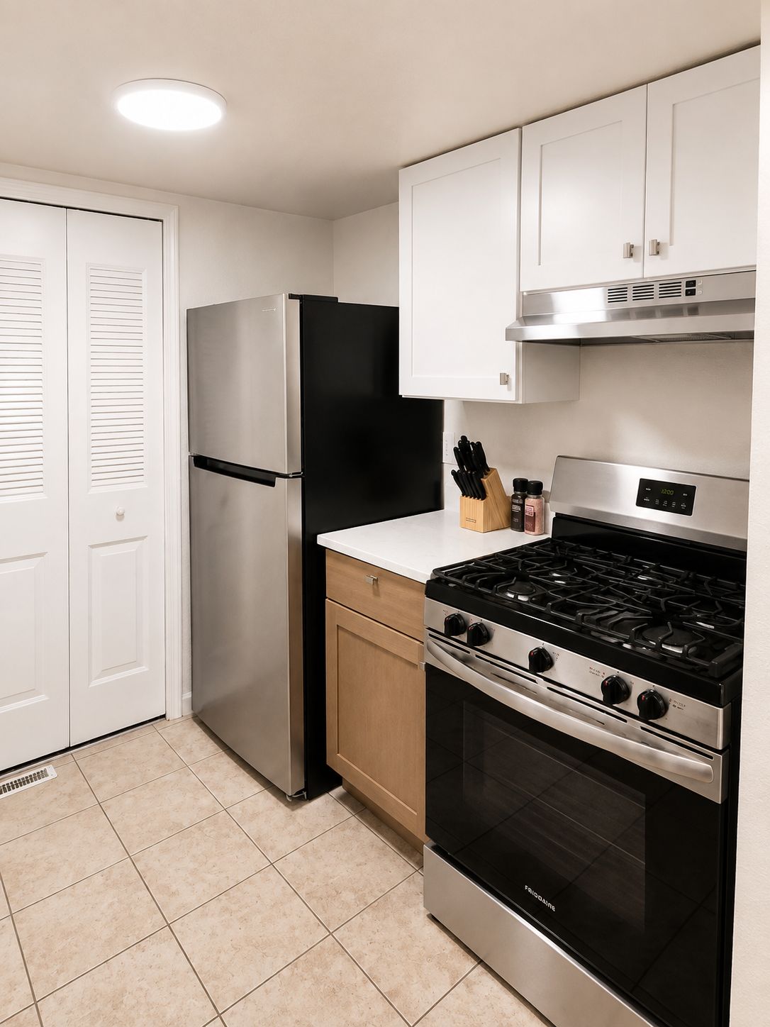 A modern kitchen with a stainless steel refrigerator, a gas stove, and a built-in oven.