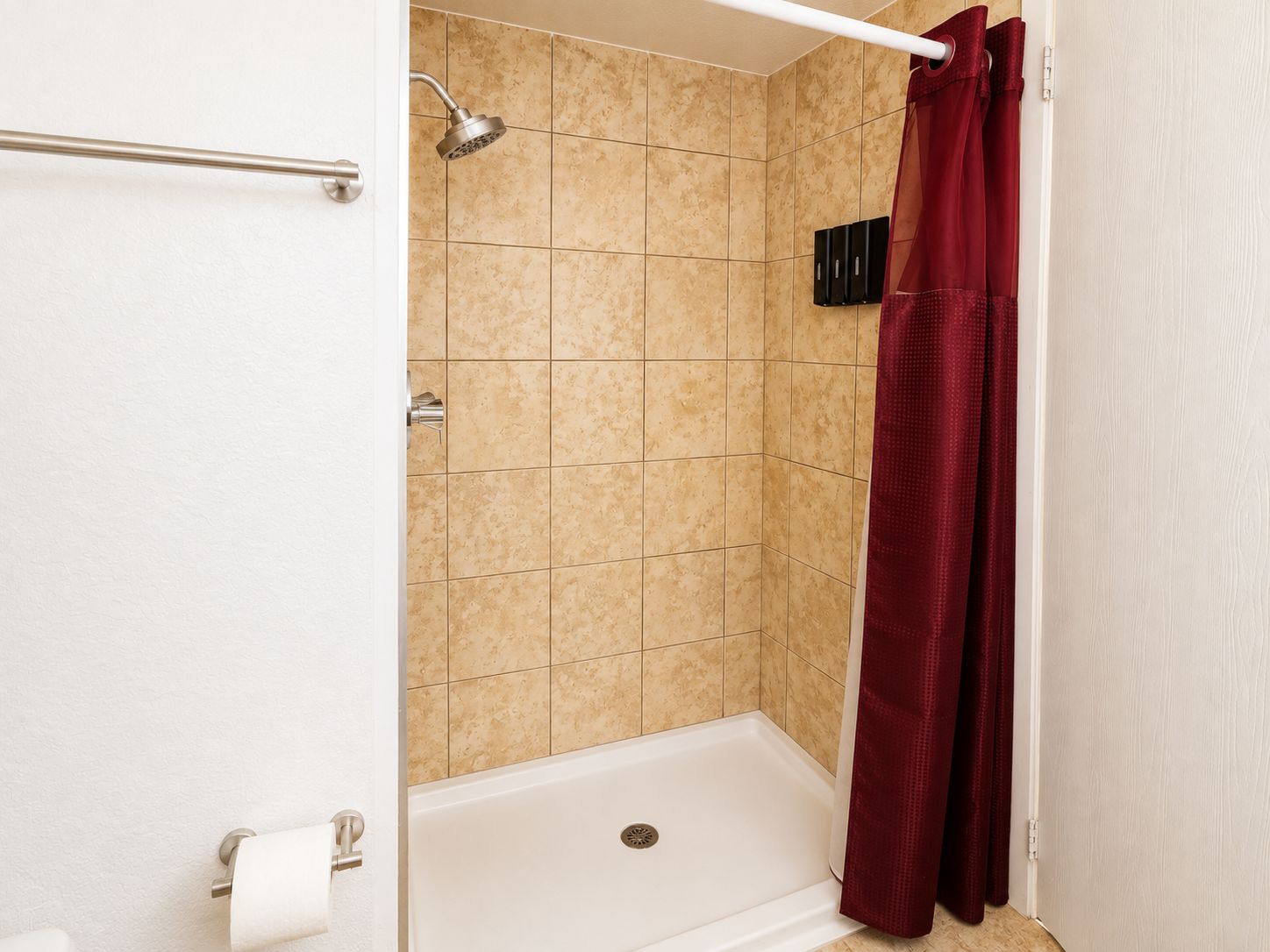 Une salle de bain avec une douche, des toilettes et un porte-serviettes.