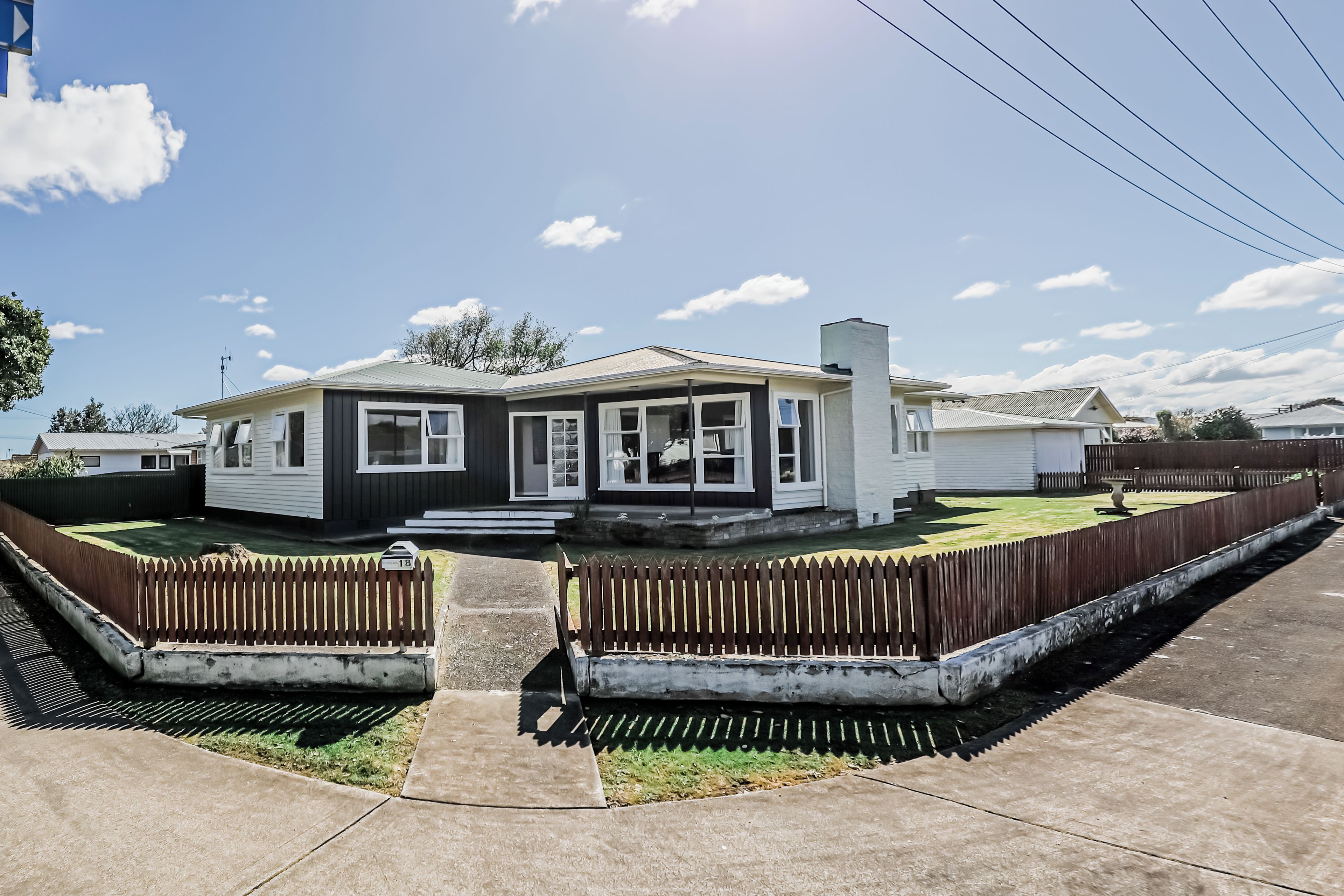 A single-story house with a front porch, a garage, and a fenced yard.