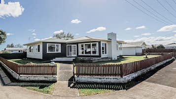 A single-story house with a front porch, a garage, and a fenced yard.