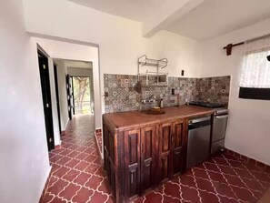 A kitchen with a patterned backsplash, wooden cabinets, and a built-in dishwasher. - Just 5 minutes from the archaeological site! Ideal family apartment with a garden (Malinalco)
