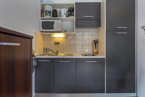 A compact kitchen with a microwave, coffee maker, and cabinets. - 200m from ski slopes, floor -1, swimming pool, balcony, tv, ski locker, 25m², Les Orres (Les Orres)