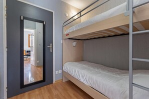 A bunk bed room with a door leading to another room, a light switch, and a power outlet on the wall. - 200m from ski slopes, floor -1, swimming pool, balcony, tv, ski locker, 25m², Les Orres (Les Orres)