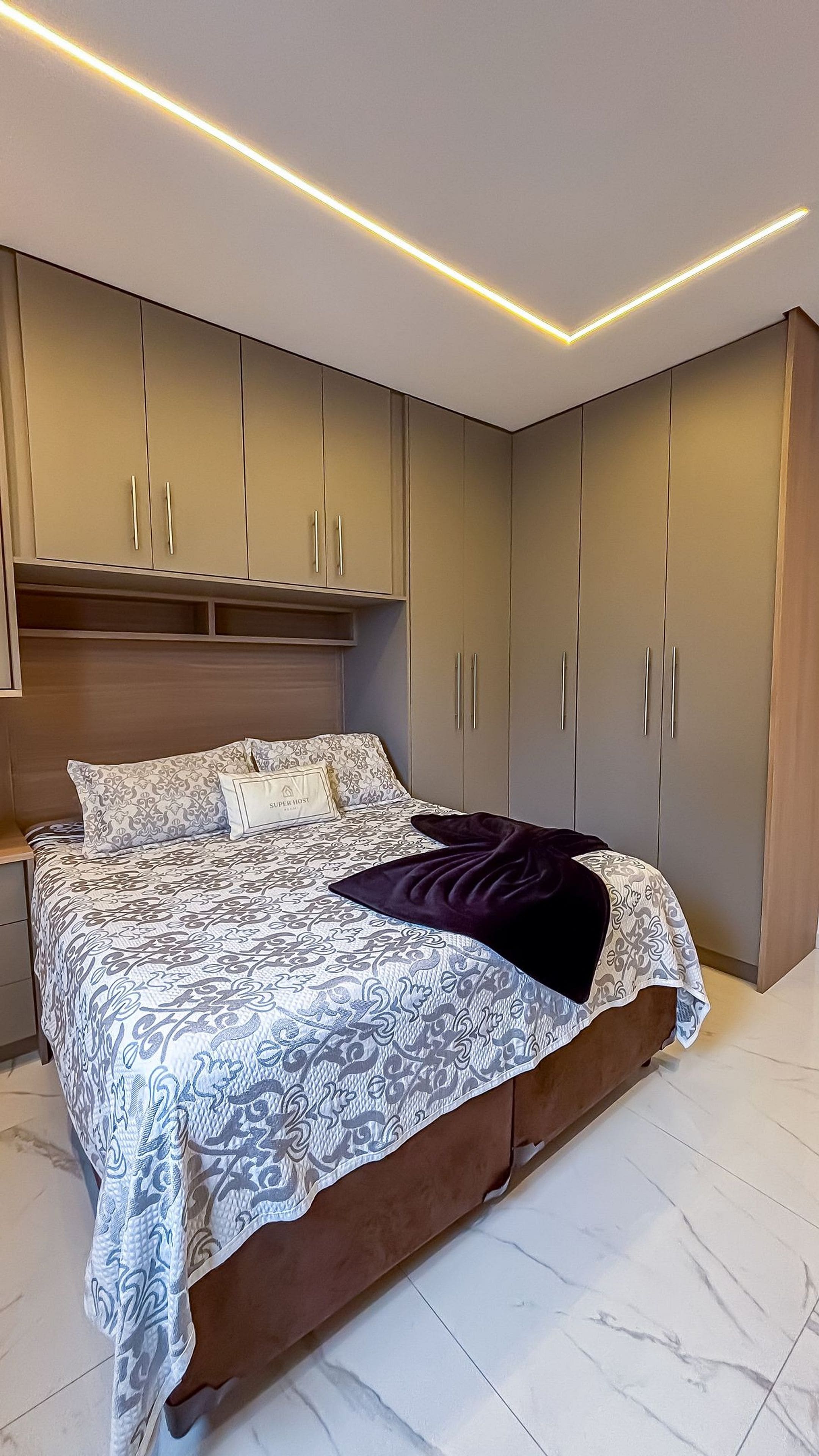 A bedroom with a bed, a nightstand, a wardrobe, and a headboard.