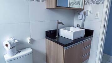 A modern bathroom with a toilet, sink, and mirror.
