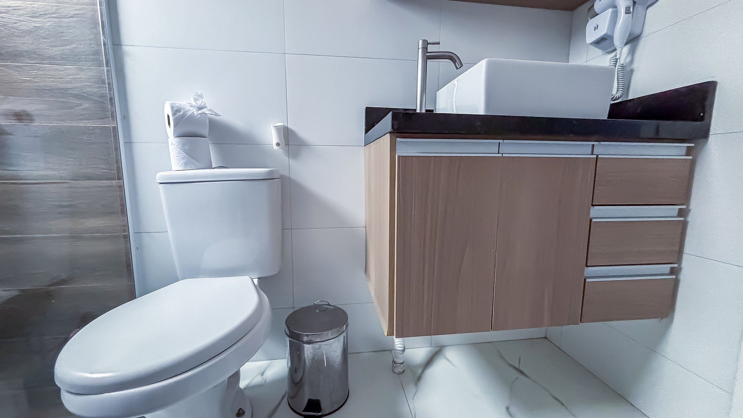 Uma casa de banho moderna com sanita, lavatório e armário.