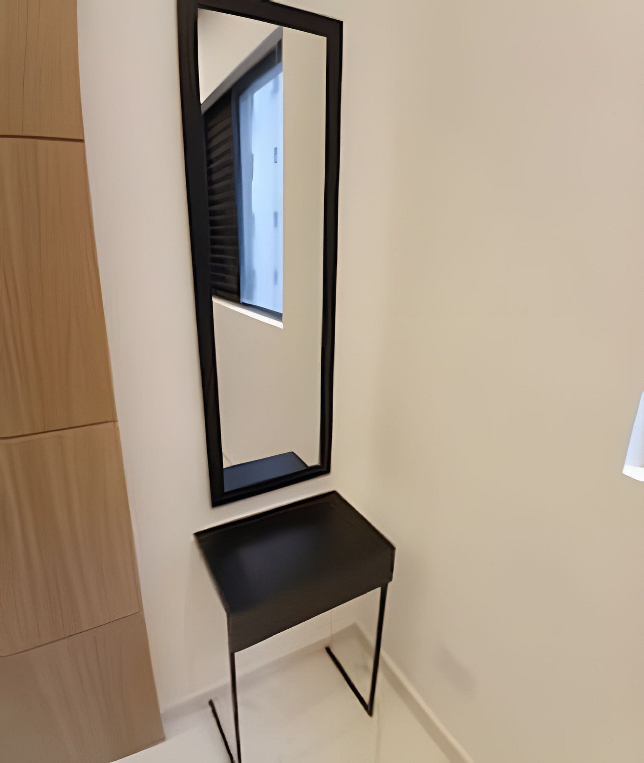 A black mirror with a stand in a hallway.