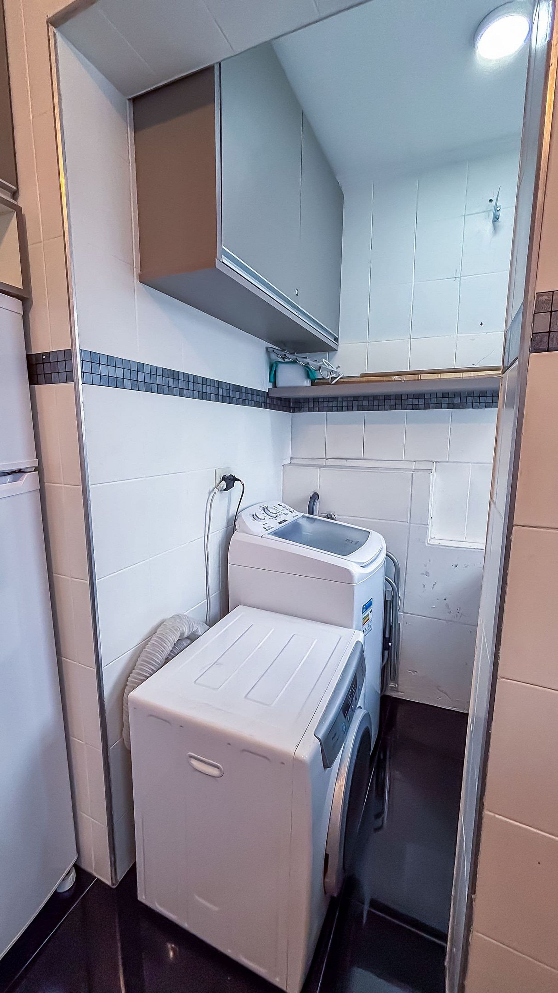 A compact laundry room with a washing machine, dryer, and a small countertop.
