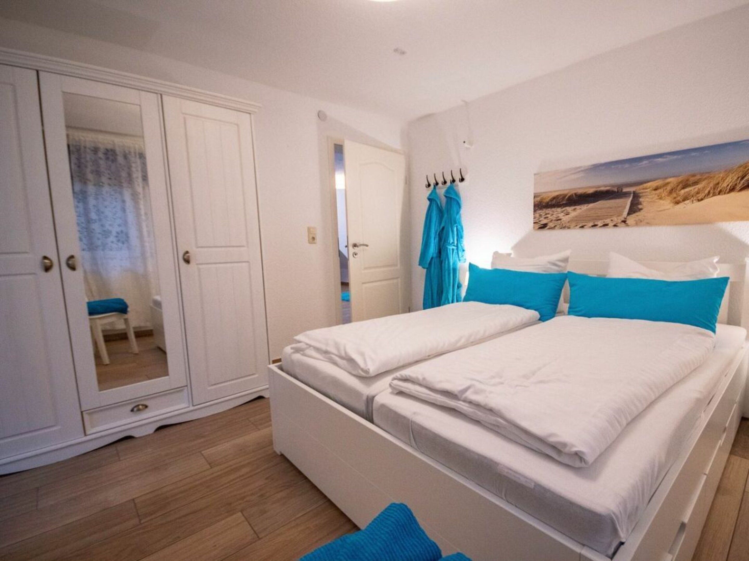 A bedroom with a bed, a wardrobe, and a bathroom visible through an open door.