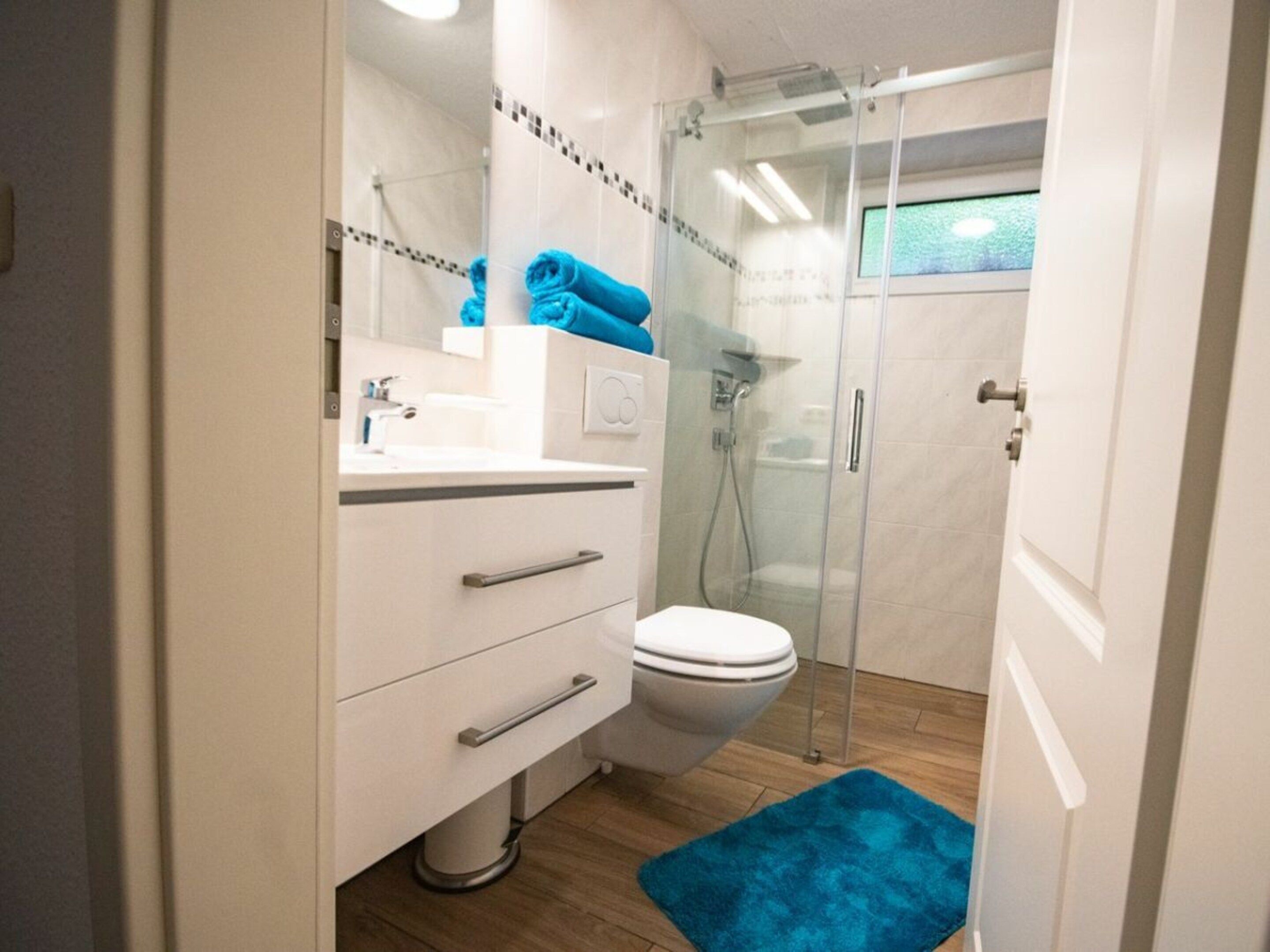 A modern bathroom with a toilet, sink, and shower area.