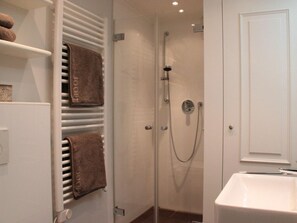A bathroom with a shower, a sink, and towel racks. - Holiday Apartment in Sylt With 2 Bedrooms (Sylt)