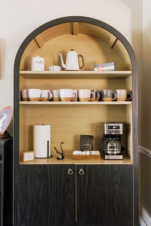 Ein Kaffeeangebot mit Kaffeemaschine, Tassen und Wasserkocher.
