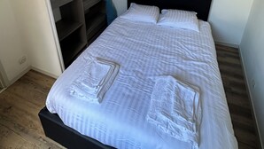 Een slaapkamer met een bed, een kledingkast en een badkamer.