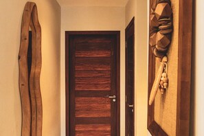 A wooden door with a metal handle, flanked by wooden wall decorations.
