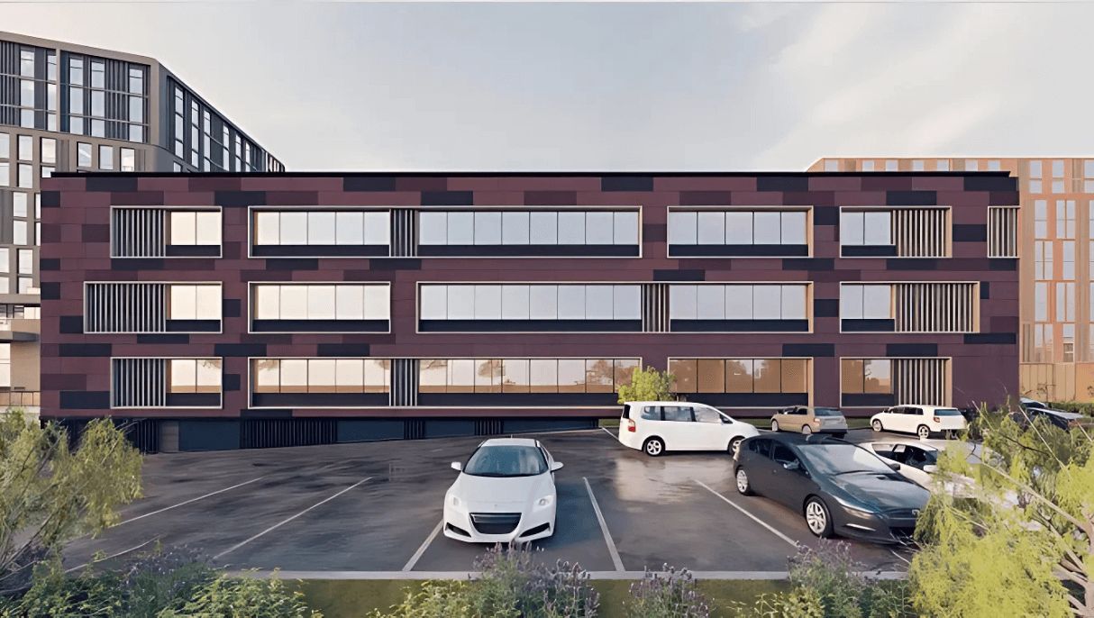 A multi-story building with a parking lot in front.