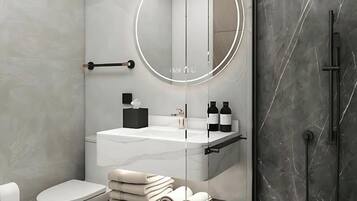 A modern bathroom with a white toilet, a round mirror, a white sink, and a black towel rack.