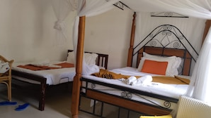 A room with two beds, each with a canopy, and a chair with a yellow cushion. - Mbita Tourist Hotel (Mbita)