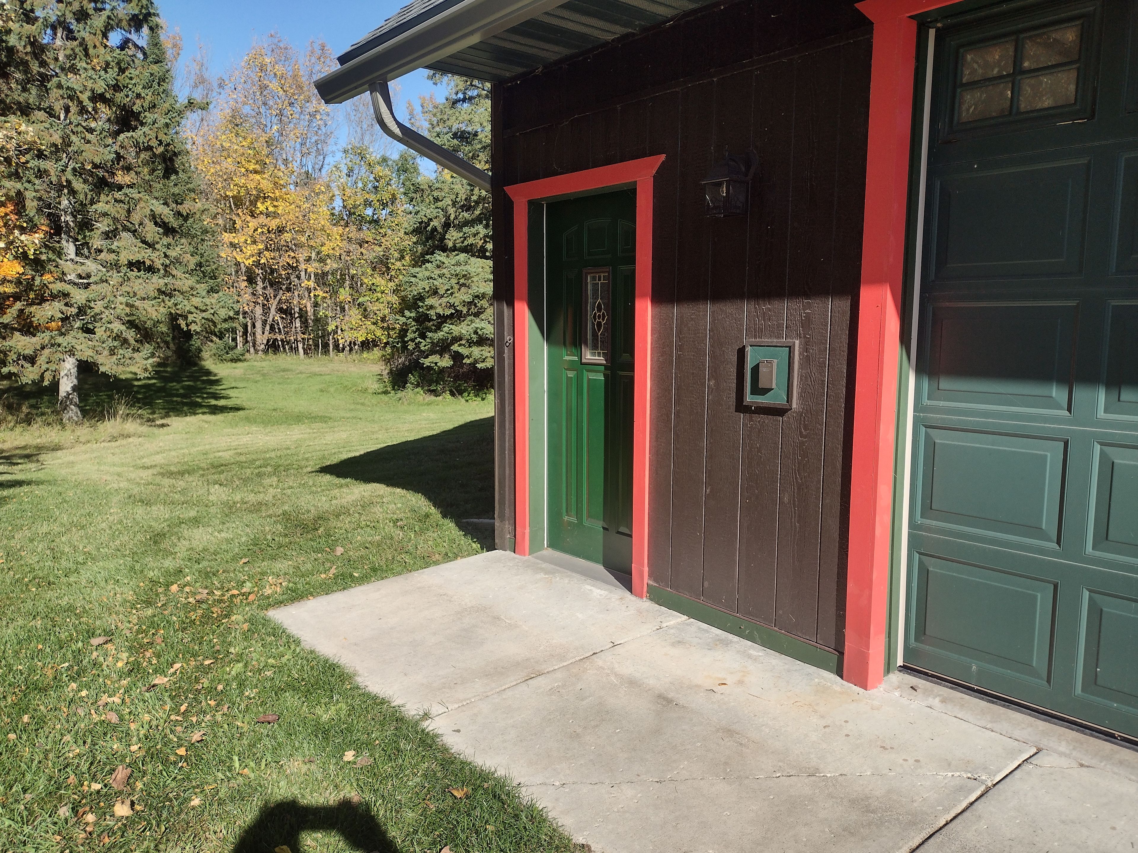A house with a green door and a garage door.