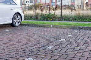A white car parked on a paved area with a curb and a small sign with the number 63. - Nr Edinburgh/Rosyth Dockyard Stylish Home Sleeps 6 (Fife)