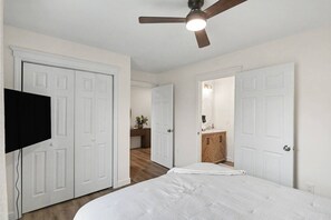 A bedroom with a bed, a ceiling fan, and a television mounted on the wall. - New 4BR Home | Ideal for Families & Teams (Dayton)