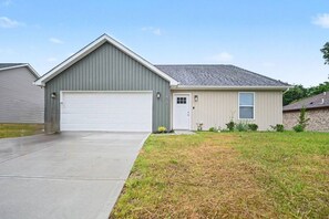 A single-story house with a garage, a front door, and a small porch area. - New 4BR Home | Ideal for Families & Teams (Dayton)