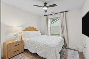 A bedroom with a bed, bedside table, lamp, and a ceiling fan. - West Dayton New 4BR/3BA Home | Modern & Spacious (Dayton)