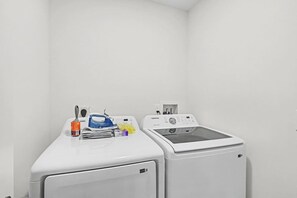 Una sala amb bugaderia, amb dues rentadores i un assecador.