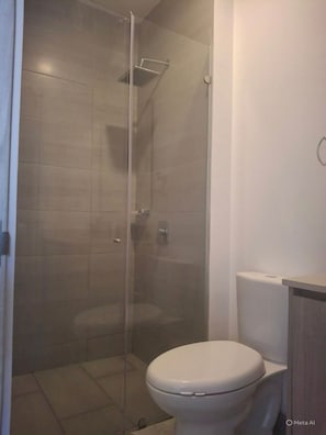 Een douche, handdoeken, zeep, toiletpapier