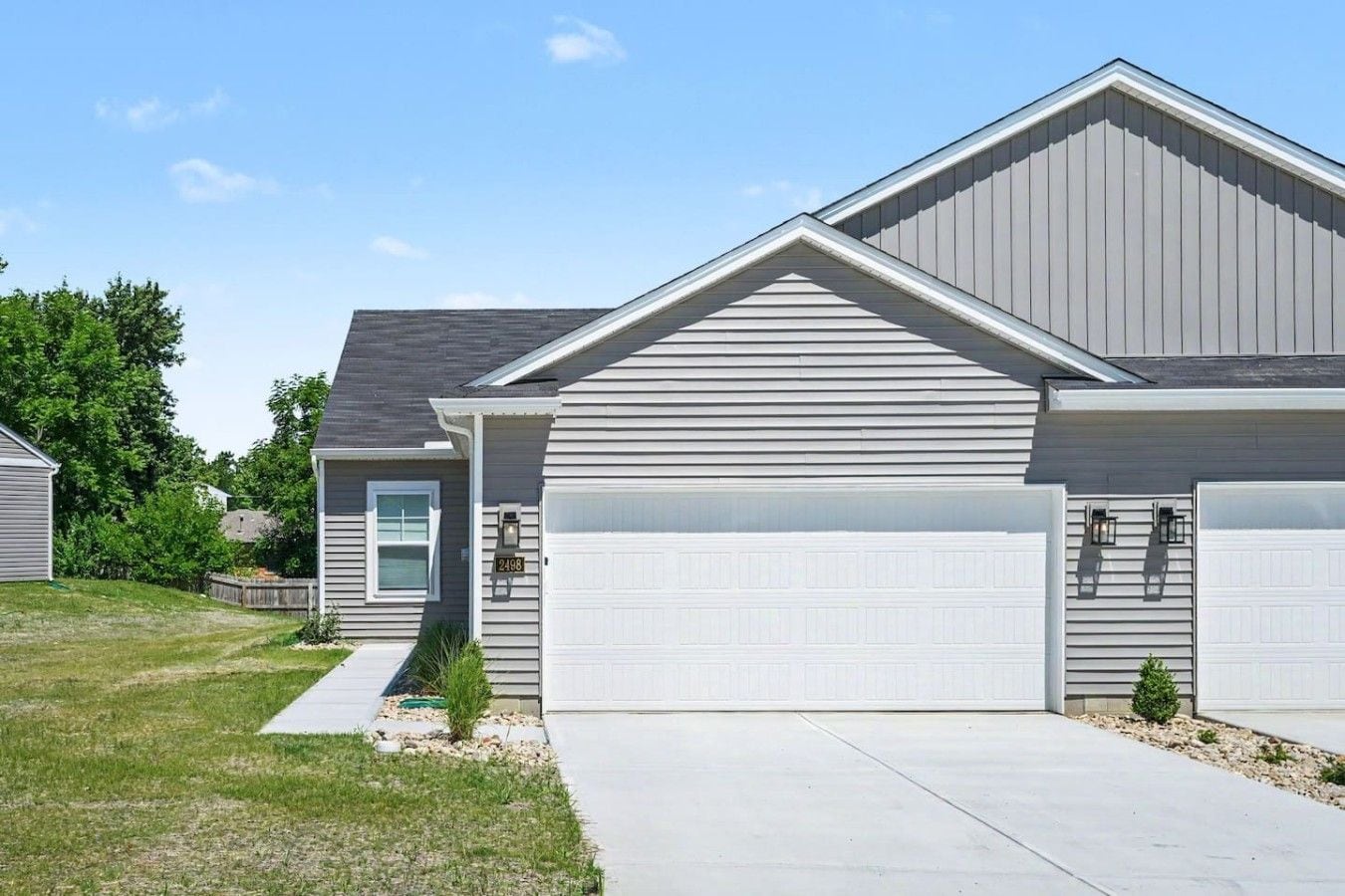 A residential house with a garage, a front door, and a small front yard.