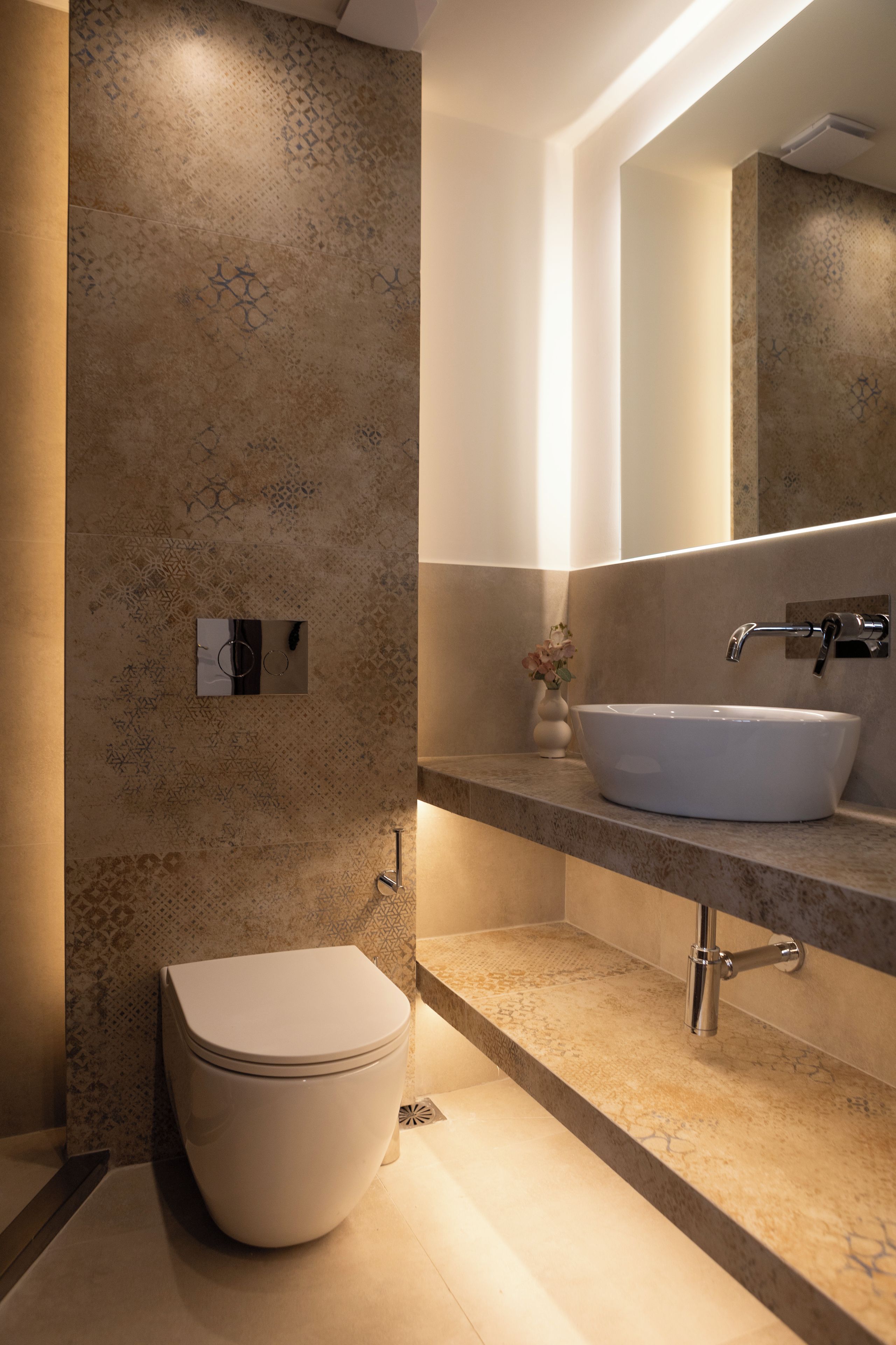 A modern bathroom with a toilet, sink, and mirror.