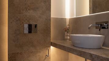 A modern bathroom with a toilet, sink, and mirror.