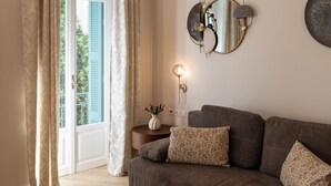 Un salon moderne avec un canapé, une table basse ronde et un miroir fixé au mur.