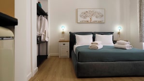 Une chambre à coucher avec un lit, des lampes de chevet, une table de chevet, une armoire et un tableau au mur.
