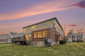 A two-story house with a deck, satellite dish, and a well-maintained lawn. - Freshly Renovated 4 Bedroom Home In Centerville OH (Dayton)