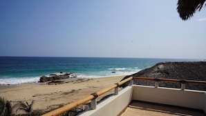 A beach view from a balcony with a railing, overlooking the ocean and a sandy shore. - Pacific Dreams Hotel Suites  (Agua Blanca, Cozoaltepec)