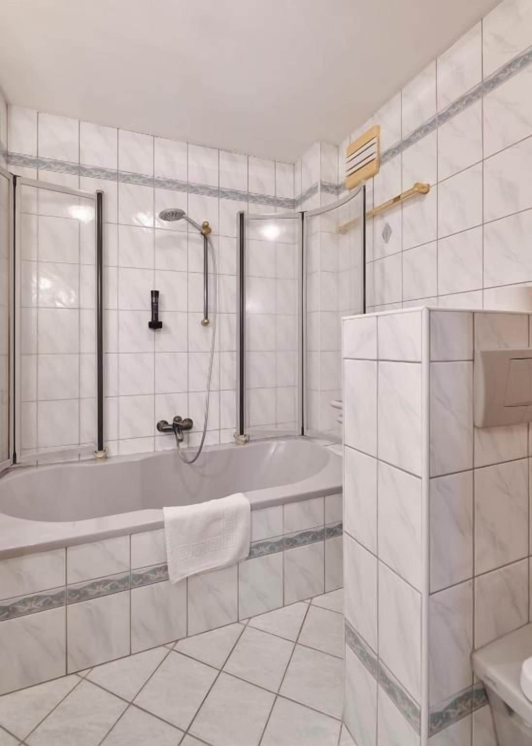 Een moderne badkamer met een vrijstaand bad, een douchecabine en een toilet.