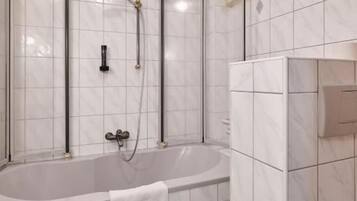 Een moderne badkamer met een vrijstaand bad, een douchecabine en een toilet.