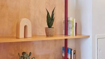 Una estantería con libros, una planta pequeña en maceta y un objeto decorativo.