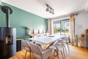 A modern kitchen with a central island, a built-in stove, and a dining area with a white table and chairs. - The House of Burgundy in downtown Dijon (Dijon)