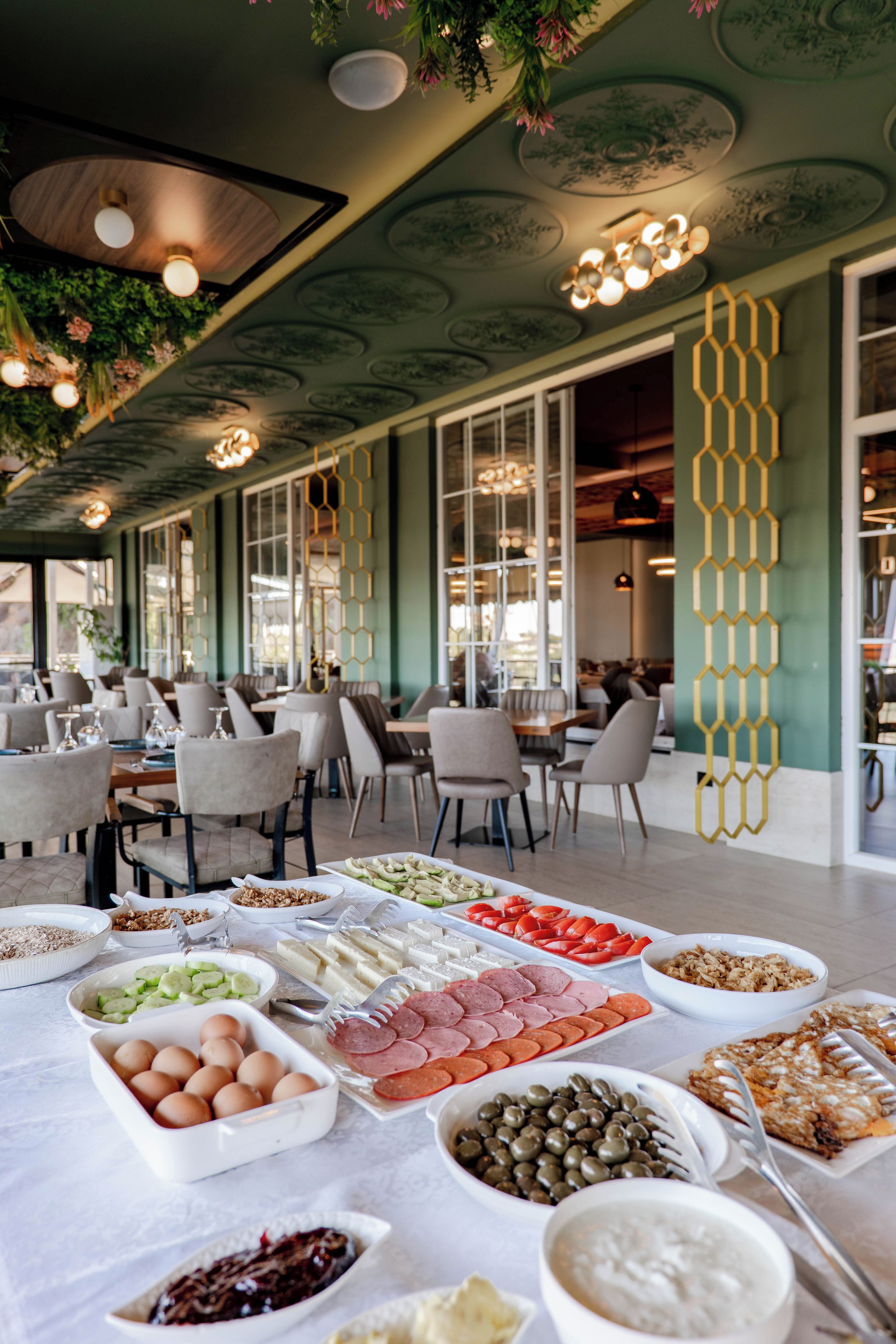 A buffet setup with various food items and a seating area with tables and chairs.