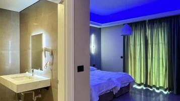 Habitación de hotel con baño, una cama y vistas al exterior.
