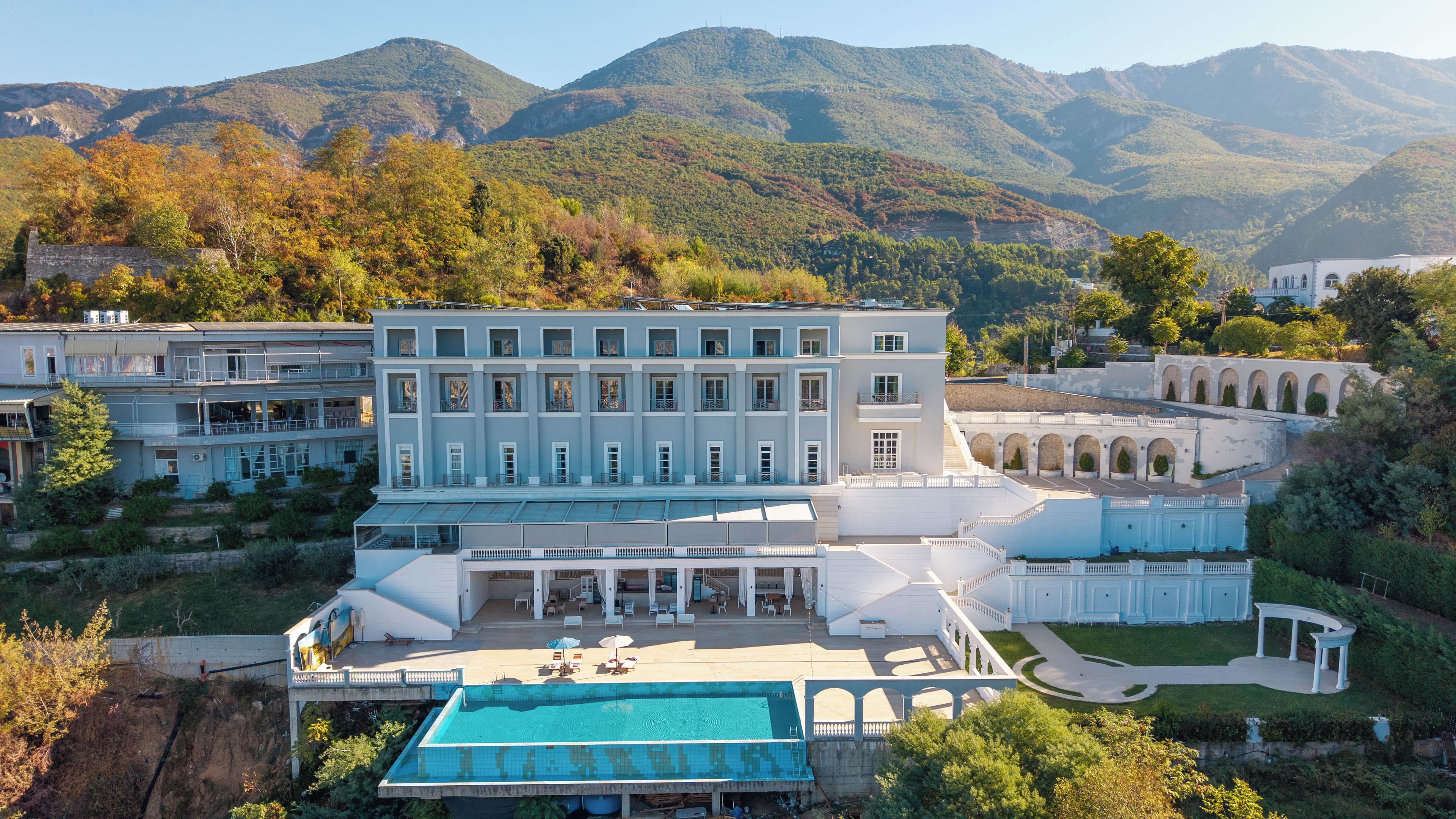 Un grand hôtel comprenant plusieurs bâtiments, une piscine et situé dans un cadre montagneux.