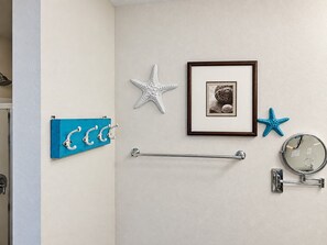 A bathroom with a towel rack, a framed picture, a starfish decoration, and a round mirror. - Rae of Sunshine 3BR PCB Townhome, Sleeps 6, Great Family Getaway! (Panama City Beach)