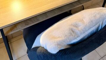 Ein Holztisch mit einer Lampe, einem Topforchidee und zwei Wasserflaschen.