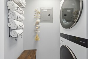 A laundry room with a wall-mounted towel rack, a power outlet, a decorative hanging ornament, and a washing machine. - Long Beach Resort Beachfront Studio with Ocean View Balcony, Sleeps 4, Tower 1 (Panama City Beach)