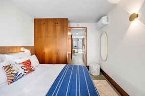 A hotel room with a bed, a wardrobe, a bathroom, and a view of the outside. - Azure: 1BR with AC & Parking | Urban Garden (Porto)