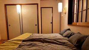 A hotel room with a bed, two doors, and a window with blinds. - GrandHOUSE SHINJUKU 301 (Nakano City)