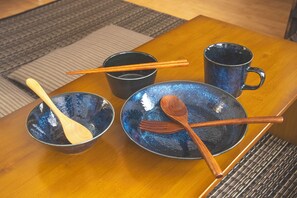 A wooden table with a blue ceramic bowl, a black mug, and a wooden spoon. - WabiSabiROOM SHINJUKU 201 (Nakano City)