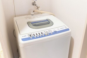 A white water heater with a digital display and control panel, connected to a wall-mounted faucet. - WabiSabiROOM SHINJUKU 201 (Nakano City)