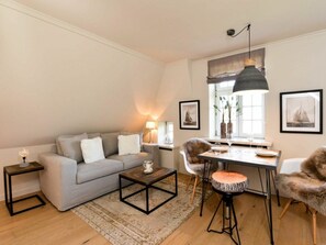 Una sala de estar con un sofá, una mesa de centro y un comedor con sillas y una mesa.